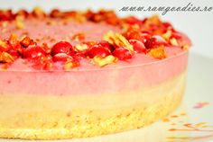 a close up of a cake on a plate with nuts and cranberry toppings