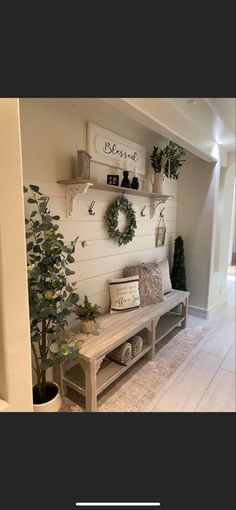 the entryway is decorated with greenery and wreaths on the wall, along with a bench