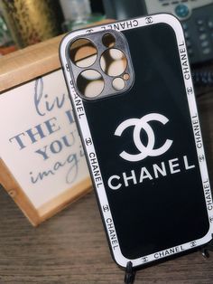 a chanel phone case sitting on top of a wooden table