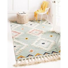 a white chair sitting on top of a rug next to a door with a yellow blanket