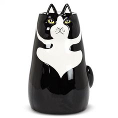 a black and white cat shaped vase with yellow eyes on it's face, sitting in front of a white background