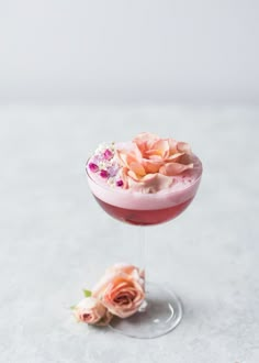 a pink cocktail with flowers on the rim