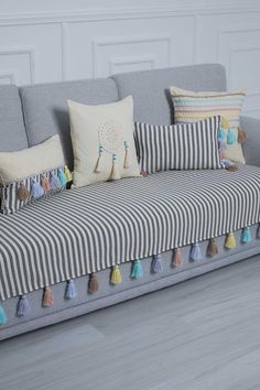 a striped couch with tassels and pillows on it