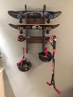 a wall mounted snowboard rack with skis and gloves hanging from it's sides