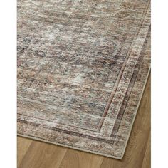 an area rug with wood flooring and a beige, blue, red and green color scheme