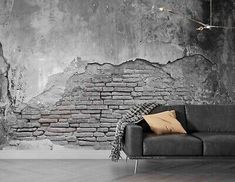 a black couch sitting in front of a brick wall