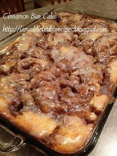 cinnamon bun cake with icing in a glass baking dish on a counter top, ready to be eaten