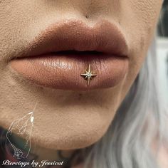 a close up view of a woman's nose with a star piercing on it