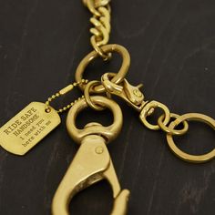 a close up of a gold colored metal keychain with a tag on it