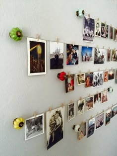 many pictures are hanging on the wall with clothes pins and magnets attached to them