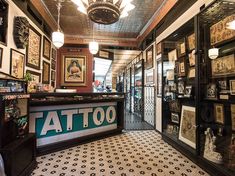 the inside of a tattoo shop with lots of framed pictures on the walls and ceiling