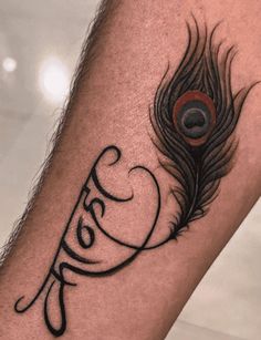 a close up of a person's leg with a tattoo on it and a peacock feather