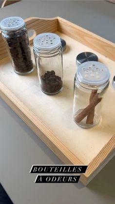 three jars filled with spices on top of a wooden tray