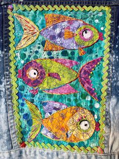 a jacket with fish painted on it and the back pocket is made from an old pair of jeans