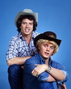 two men in cowboy hats pose for a photo on the set of tv show, grease