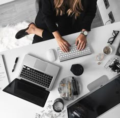 a woman sitting at a desk using a laptop computer with her hands on the keyboard