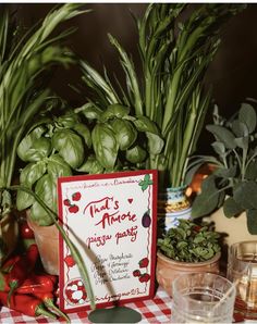 there is a sign on the table next to some potted plants and other items