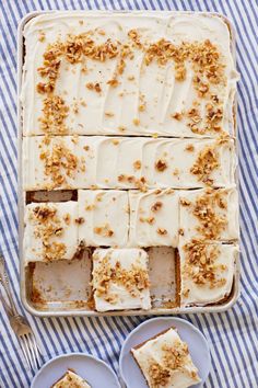 several slices of cake sitting on plates next to each other with white frosting and chopped walnuts