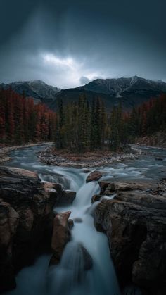 a long exposure photo of a river running through some rocks