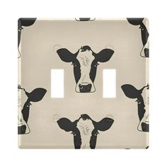 a black and white cow pattern on a light switch cover with two toggles