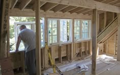 a man standing in the middle of a room under construction