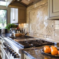 a stove top oven sitting inside of a kitchen next to a bowl of oranges