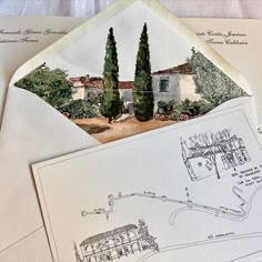 an envelope with a drawing of a house and trees on the front is open to reveal information about what's inside