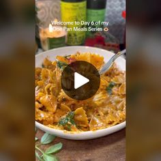 a plate of pasta with cheese and spinach on it is featured in the video