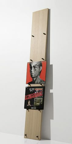 a skateboard that is hanging on the side of a wall with some stickers attached to it