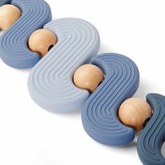 three wooden toys sitting on top of each other in the shape of wavy lines and circles