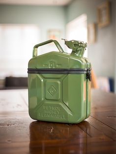 a green gas can sitting on top of a wooden table