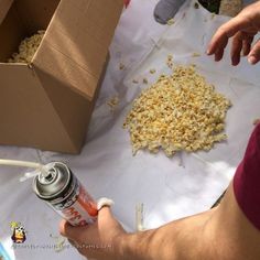 a person is pouring something out of a can onto a table with boxes and other items