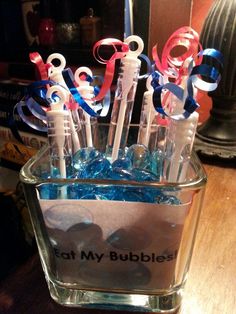 some toothbrushes are in a glass container with blue and red streamers on them