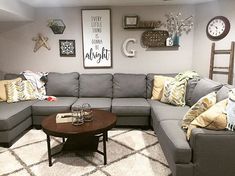 a living room with grey couches and yellow pillows on the rugs in front of it