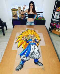 a woman standing in front of a table that has a dragon on it and an image of gohan