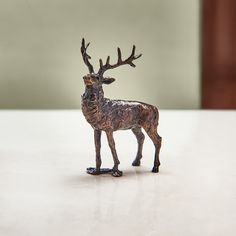 a small bronze deer figurine sitting on top of a table