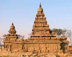 an intricately carved stone structure in the middle of a field with trees and rocks