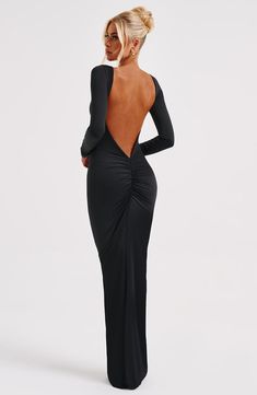 a woman wearing a black dress with an open back