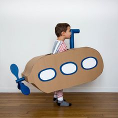 a little boy in a cardboard boat costume