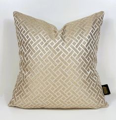 a gold and white pillow sitting on top of a table