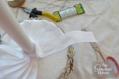 the bride's dress is being sewn on with scissors and other crafting supplies