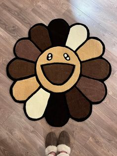 a person standing in front of a rug with a smiling flower on it's face