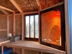 the inside of a chicken coop with wooden walls and windows