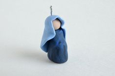 a figurine with a blue cloth draped over it's head on a white surface