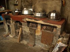 an old kitchen with pots and pans on the stove top, next to a newspaper