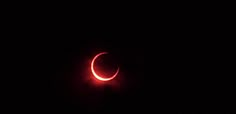 a red crescent eclipse in the night sky