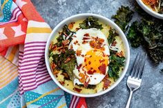 two bowls filled with food on top of a table next to a fork and napkin