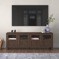 a large flat screen tv mounted to the side of a wooden entertainment center in a living room