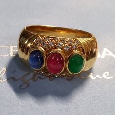 For Your Consideration, A Gorgeous 18k Yellow Gold Ring. Cabochon Blue Shappires, Ruby And Emerald, Surrounded By 26 Diamonds. The Gems Have Slight Inclusions (Si1) And Are Beautifully Complemented By The Gold Band. Diamond Carat Weight 0.10 Approximately 26 Stones Near Colorless, Slightly Included Sapphire Carat Weight 0.53 Strong Saturation, Moderately Included Ruby Carat Weight 0.51 Saturation Strong Moderately Included Emerald Carat Weight 0.35 Saturation Strong Moderately Included. The Ring Levian Rings, 18k Yellow Gold Ring, Diamond Carat, Yellow Gold Ring, Gold Band, Womens Jewelry Rings, Gold Bands, Red Gold, Gold Ring