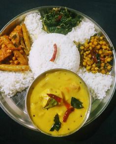 a metal plate topped with rice and veggies